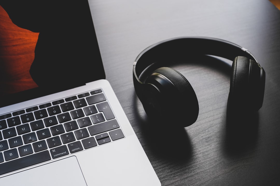 Headphones beside a laptop representing browser and Windows audio output troubleshooting