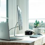 Laptop, monitor and camera in a modern home office technology setup