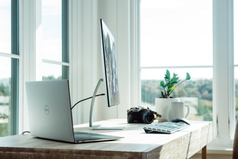 Laptop, monitor and camera in a modern home office technology setup