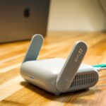 Modern wireless router with Ethernet and power cables on a desk