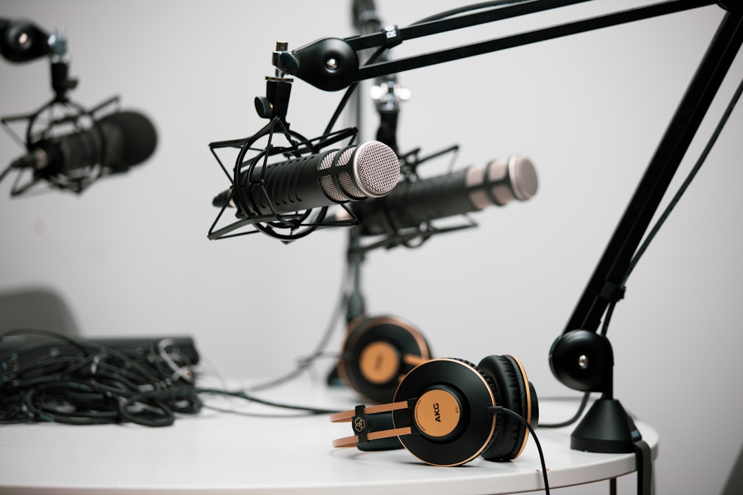 Podcast microphones on boom arms with headphones in a studio setup