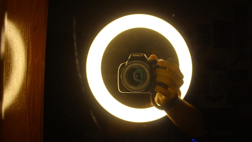 Camera positioned in front of a circular ring light for video creation