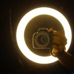 Camera positioned in front of a circular ring light for video creation