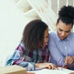 People collaborating at a laptop for small business client management